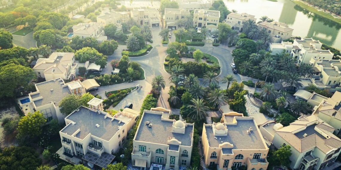Aerial view of a family villa community in Dubai with gardens, pools and a lake
