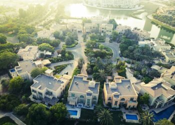 Aerial view of a family villa community in Dubai with gardens, pools and a lake